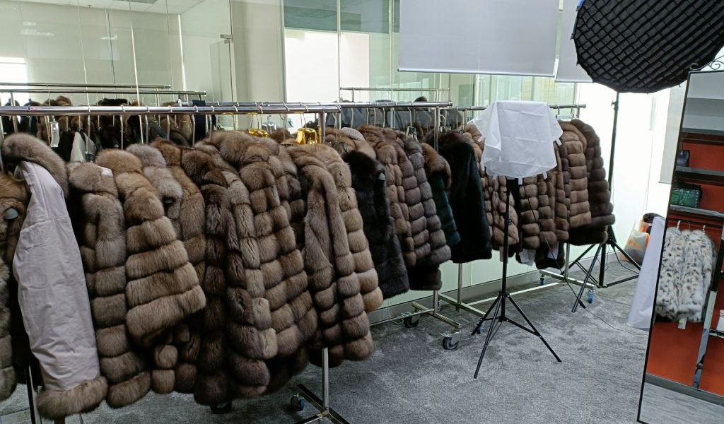 Fur coat photo studio with white lights and fur racks